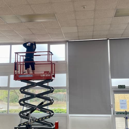 Large Roller Blinds being fitted with scissor lift in school studio